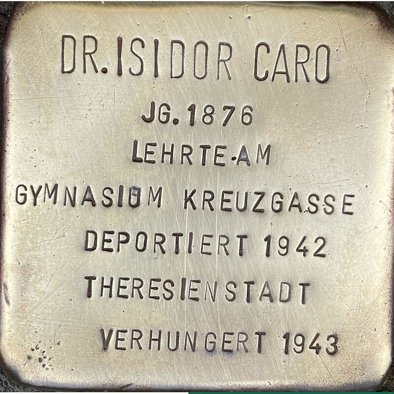 Isidor Caro Isidor Caro (6.10.1876 in Żnin gestorben am 28.08.1943 in Theresienstadt) war ein deutscher Rabbiner der jüdischen Gemeinde Köln und Religionslehrer am Gymnasium Kreuzgasse. Er war mit Klara Beerman verheirate, das Ehepaar hatte zwei Kinder, Hermann und Rut, und wohnte auf Ehrenfeldgürtel 171. Isidor und Klara Caro widmeten sich bis 1938 intensiv der seelsorgerischen Tätigkeit. Während des Novemberpogroms 1938 fiel Dr. Caro durch seine besonnene, furchtlose Art auf, er wollte seine inhaftierten Glaubensbrüder besuchen und ließ sich auch durch Drohungen nicht einschüchtern. Schon vor 1941 mussten ihre Wohnung verlassen und wohnten dann im Hinterhaus der Synagoge Roonstraße 50, mit 13 anderen Personen auf sehr kleinem Raum. Im Juni 1942 wurde der erste Transport jüdischer Kölner nach Theresienstadt aufgerufen. Die Caros hatten sich freiwillig zur Begleitung des ersten »Judentransports« zur Verfügung gestellt. Isidor Caro verstarb am 28. August 1943, er ist verhungert, seine Frau Klara überlebte und zog nach 1945 zu ihrer in die USA geflohenen Tochter. Der Sohn Hermann, Schüler der Kreuzgasse, wurde im Konzentrationslager Auschwitz ermordet. Quelle: Der gesamte Text fusst auf dem Eintrag „Isidor Caro“ auf Wikipedia.com und Kirsten Serup-Bilfeldt: Stolpersteine, Köln 2003, S. 33 – 40, Informationen des NS-Dokumentationszentrums Köln, den Einträgen in Yad-Vashem & Arolsen-Archives.