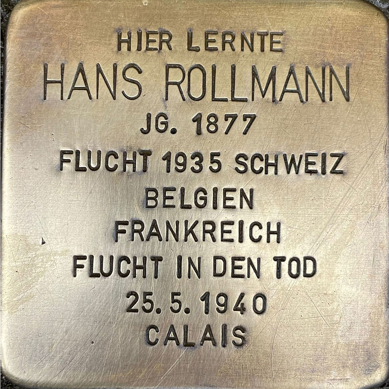 Hans Rollmann Hans Rollmann (geboren am 10.8.1877 in Köln, gestorben am 3.09.1944 in Calais) wurde nach dem Schulabschluss an der Kreuzgasse wie sein Vater Schuhfabrikant und war Miteigentümer der bekannten Schuhfabrik ROMIKA. Er heiratete Marie Hertz und ihre drei Söhne Ernst, Heinz und Klaus besuchten auch die Kreuzgasse. Hans Rollmann stand der SPD nahe und Jude, deswegen und weil die Nationalsozialisten schnell auf seine lukrative Fabrik aufmerksam wurden, wurde ab 1933 seine Fabrik schnell in Zahlungsschwierigkeiten gebracht, er selbst verleumdet, als Verbrecher diffamiert und per Haftbefehl gesucht. Hans Rollmann griffen diese Schwierigkeiten auch gesundheitlich an. Er floh in die Schweiz und musste von dort aus zu sehen, wie ihm sein Besitz widerrechtlich entzogen wurde. Die Rollmanns zogen nach Belgien und eröffneten dort eine Schuhfabrik. Nach dem deutschen Überfall auf Belgien flohen die Söhne in die USA, der schwer erkrankte Hans Rollmann und seine Ehefrau beginnen gemeinsam Suizid. Quelle: Der gesamte Text fußt auf Informationen der Dokumentation dieser Enteignung: Heinz Ganz-Ohlig: ROMIKA – „eine jüdische Fabrik“, Trier 2012, Informationen im Gedenkbuch der Kreuzgasse und Informationen des NS-Dokumentationszentrums Köln.